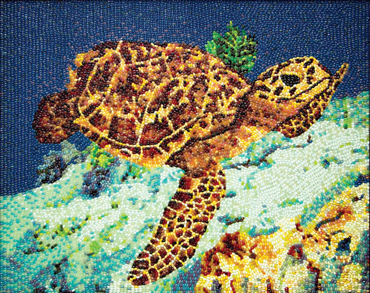A dazzling tribute to the majestic Hawksbill Sea Turtle. Found in tropical waters of the Atlantic, Pacific and Indian Oceans, this depiction finds the critically endangered turtle in a sea of Blueberry Jelly Belly beans.